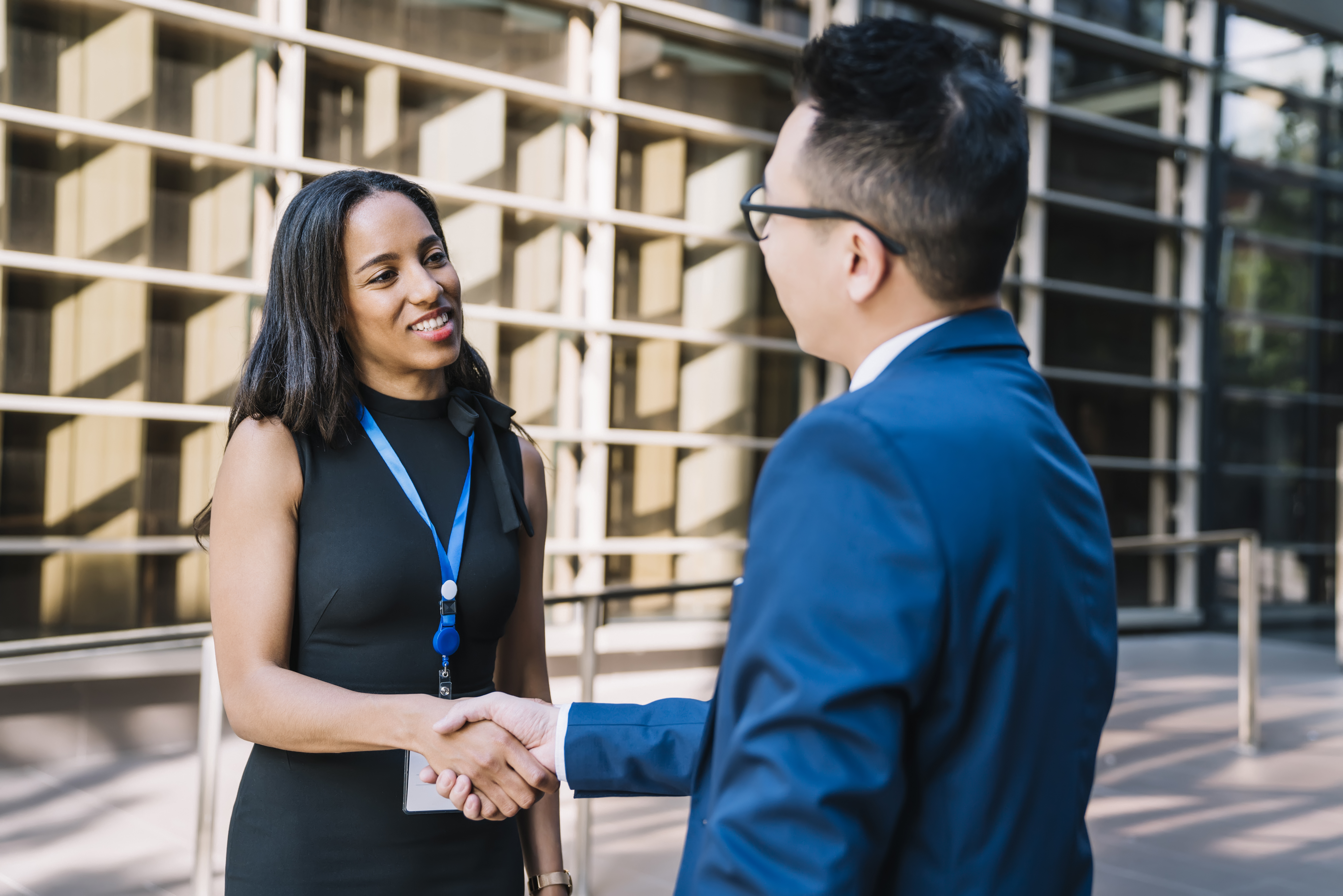 Two young business professionals shaking hands.