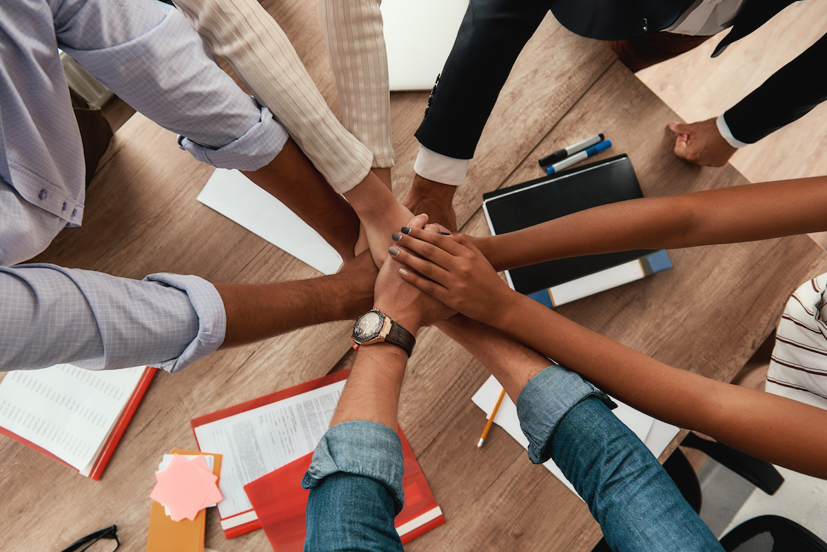 A multicultural team joining hands to signify teamwork